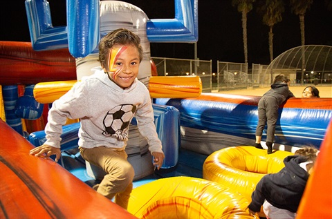 Smiling boy running in inflatable play equipment