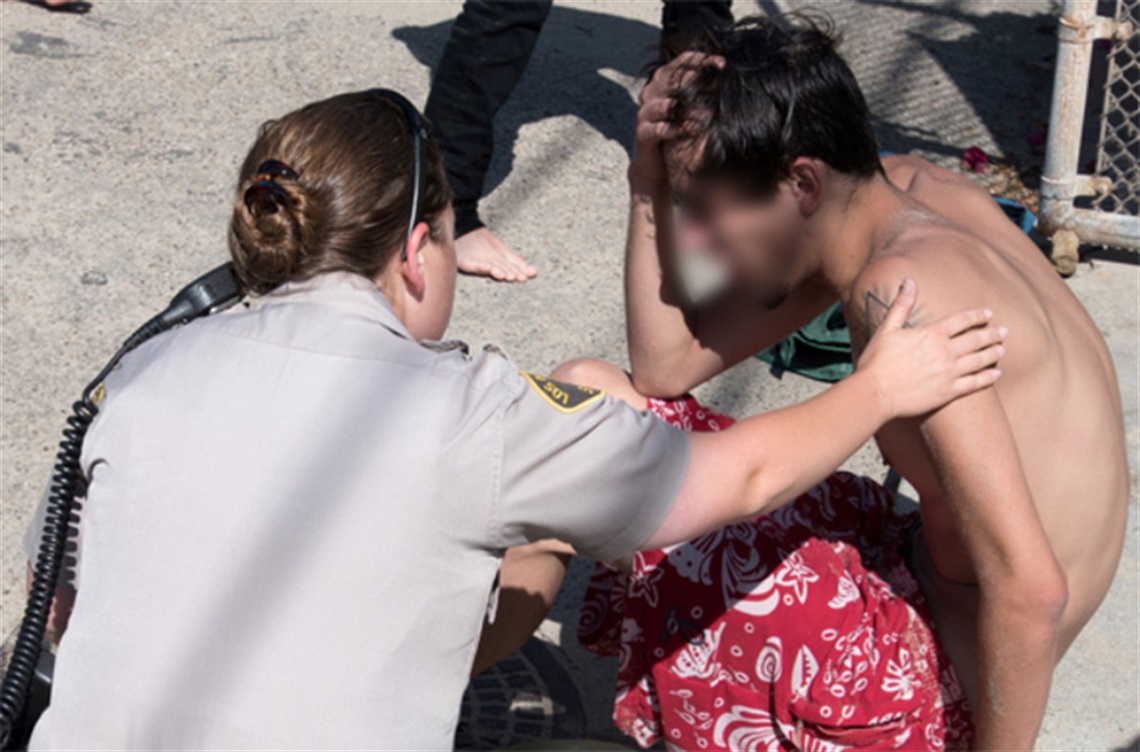 Deputy Sheriff speaking to a young adult 